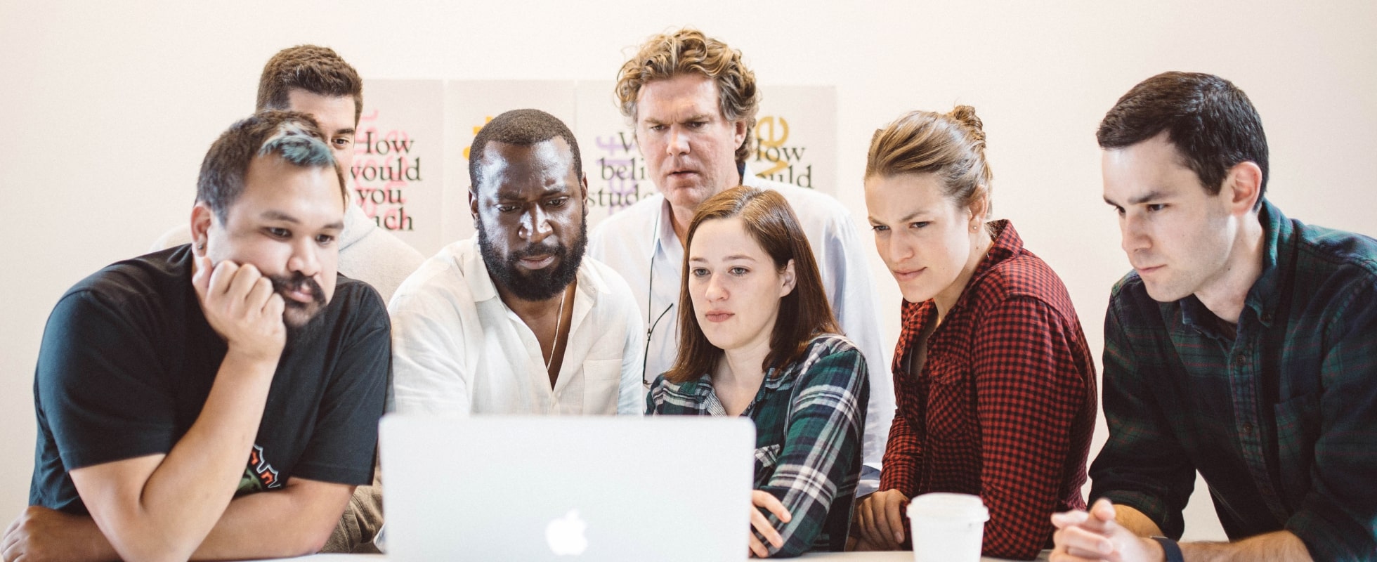 A group collaborating around a laptop